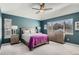 Bedroom with a tray ceiling, natural light, neutral paint, and a ceiling fan at 7998 E Vassar Dr, Denver, CO 80231