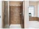 Modern bathroom featuring tiled shower with glass door and tub with window at 3661 S Perth Cir # 6-101, Aurora, CO 80013