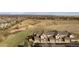 A townhome exterior with attached garages, manicured landscaping, and a view of the open land at 3661 S Perth Cir # 6-101, Aurora, CO 80013