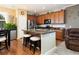 Kitchen with island, stainless steel fridge, wood cabinets, and two bar stools at the counter at 3661 S Perth Cir # 6-101, Aurora, CO 80013
