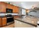 Kitchen with granite counters, stainless steel appliances, and wood cabinets at 3661 S Perth Cir # 6-101, Aurora, CO 80013