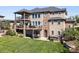 Expansive backyard with a stone-accented home, featuring multiple decks and a hot tub for outdoor relaxation at 12648 Waterside Ln, Longmont, CO 80504
