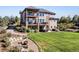 Expansive backyard with a fire pit, lush lawn, and multi-tiered deck at 12648 Waterside Ln, Longmont, CO 80504