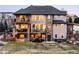 Backyard featuring a stone-accented home with multiple decks, offering an inviting space for relaxation at 12648 Waterside Ln, Longmont, CO 80504