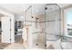Tiled shower with a glass enclosure and dual shower heads, adjoining walk-in closet at 12648 Waterside Ln, Longmont, CO 80504