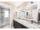 Bathroom featuring dual sinks with granite countertops and dark wood cabinetry at 12648 Waterside Ln, Longmont, CO 80504