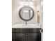 Elegant bathroom featuring a granite countertop and a stylish round mirror at 12648 Waterside Ln, Longmont, CO 80504