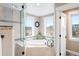 Bright bathroom featuring a large tub, tiled shower, and windows with outdoor views at 12648 Waterside Ln, Longmont, CO 80504