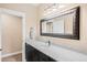 Bathroom featuring dark vanity with granite countertop and large decorative mirror at 12648 Waterside Ln, Longmont, CO 80504
