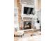 Elegant stone fireplace with a decorative mantel, built-in shelving, and a cozy seating area at 12648 Waterside Ln, Longmont, CO 80504