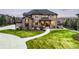 Inviting two-story home featuring a well-maintained lawn and stone accents at 12648 Waterside Ln, Longmont, CO 80504