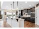 Spacious kitchen with dark wood cabinets, granite countertops, a large island, and a view overlooking the backyard at 12648 Waterside Ln, Longmont, CO 80504