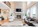 Cozy living room with a floor-to-ceiling stone fireplace, built-in shelving, and lots of natural light at 12648 Waterside Ln, Longmont, CO 80504