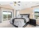 Bright main bedroom featuring a ceiling fan, balcony access, and windows with lovely views at 12648 Waterside Ln, Longmont, CO 80504