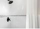 Modern shower featuring white tile walls with decorative border and matte black shower head at 12648 Waterside Ln, Longmont, CO 80504