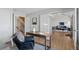 Well-lit home office space featuring hardwood floors, a comfortable chair, and access to other areas of the house at 7470 S Steele Cir, Centennial, CO 80122