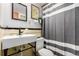 Classic bathroom features a modern sink, framed mirrors, and a stylish striped shower curtain at 1454 Jersey St # 104, Denver, CO 80220