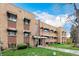 The building has a traditional brick facade with awnings and manicured landscaping at 1454 Jersey St # 104, Denver, CO 80220