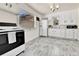 Well-lit kitchen featuring white cabinetry, modern appliances, and sleek flooring at 2171 S Cherokee St, Denver, CO 80223