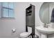 Bathroom featuring a pedestal sink, toilet, and storage cabinet at 13437 Starhawk Ln, Parker, CO 80134