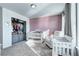 Well-appointed Bedroom featuring a soft mauve wall, a crib, a comfortable chair, and plenty of storage at 13437 Starhawk Ln, Parker, CO 80134