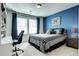 Charming bedroom featuring a blue accent wall, plush carpet, and a well-lit workspace with ample natural light at 13437 Starhawk Ln, Parker, CO 80134