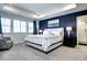 Comfortable bedroom featuring a tray ceiling, large windows, and a dark accent wall at 13437 Starhawk Ln, Parker, CO 80134