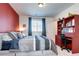 bedroom featuring a vibrant red accent wall, a twin bed, and a study area at 13437 Starhawk Ln, Parker, CO 80134