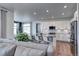 Modern kitchen with an island, bar seating, stainless steel appliances, and white cabinetry at 13437 Starhawk Ln, Parker, CO 80134