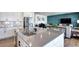 Bright kitchen featuring a gray countertop island with a sink and stainless steel appliances at 13437 Starhawk Ln, Parker, CO 80134