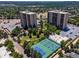 Two high-rise towers with blue tennis courts, green grass and a pond in a well-maintained community at 7877 E Mississippi Ave # 208, Denver, CO 80247