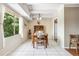 Bright dining room with white tile floors, large windows, and a classic wooden dining set at 7877 E Mississippi Ave # 208, Denver, CO 80247