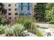 Multi-story building with large glass windows with lush greenery surrounding the property at 7877 E Mississippi Ave # 208, Denver, CO 80247