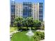 High-rise apartment building view from exterior, featuring pond with fountain and green space at 7877 E Mississippi Ave # 208, Denver, CO 80247