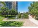High-rise apartment building view from exterior, featuring pond with fountain and green space at 7877 E Mississippi Ave # 208, Denver, CO 80247