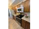 Bright kitchen with modern appliances, wood cabinets, and laminate countertops at 7877 E Mississippi Ave # 208, Denver, CO 80247