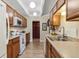 Functional kitchen features wooden cabinets, white appliances, and ample counter space at 7877 E Mississippi Ave # 208, Denver, CO 80247