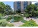 Scenic pond with aquatic plants and landscaping near the building at 7877 E Mississippi Ave # 208, Denver, CO 80247