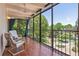 Enclosed sunroom with tile floor, seating, and scenic views of lush landscaping at 7877 E Mississippi Ave # 208, Denver, CO 80247