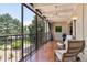 Enclosed sunroom with tile floor, seating, and scenic views of lush landscaping at 7877 E Mississippi Ave # 208, Denver, CO 80247