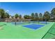 Outdoor tennis courts with blue and green surfaces, surrounded by trees at 7877 E Mississippi Ave # 208, Denver, CO 80247