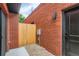 Cozy backyard with red brick wall, wooden fence, and concrete walkway at 115 W 2Nd Ave # 101, Denver, CO 80223