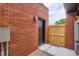 Cozy backyard with red brick wall, wooden fence, and concrete walkway at 115 W 2Nd Ave # 101, Denver, CO 80223