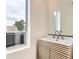 Bright bathroom featuring a stylish vanity with a modern faucet, a sleek mirror, and a window at 115 W 2Nd Ave # 101, Denver, CO 80223