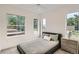Bright bedroom featuring large windows, a gray bed frame, and matching nightstand at 115 W 2Nd Ave # 101, Denver, CO 80223