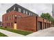 Striking exterior featuring red brick, modern black accents, and garage access at 115 W 2Nd Ave # 101, Denver, CO 80223