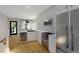 Bright, modern kitchen with stainless steel appliances, white cabinetry and tile backsplash, open to the dining area at 115 W 2Nd Ave # 101, Denver, CO 80223