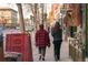 An active street scene with people walking along the sidewalk past shops at 115 W 2Nd Ave # 101, Denver, CO 80223