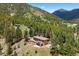 An aerial view of home surrounded by lush greenery and mountain views at 187 Marion Dr, Evergreen, CO 80439