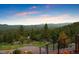 Lush green backyard with mature trees, mountain views, and easy access from the wooden staircase at 187 Marion Dr, Evergreen, CO 80439